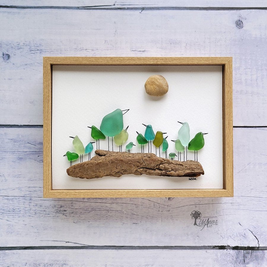 Cuadro Cotorreando de arte reciclado, vista frontal, marco marrón claro colgado en pared.