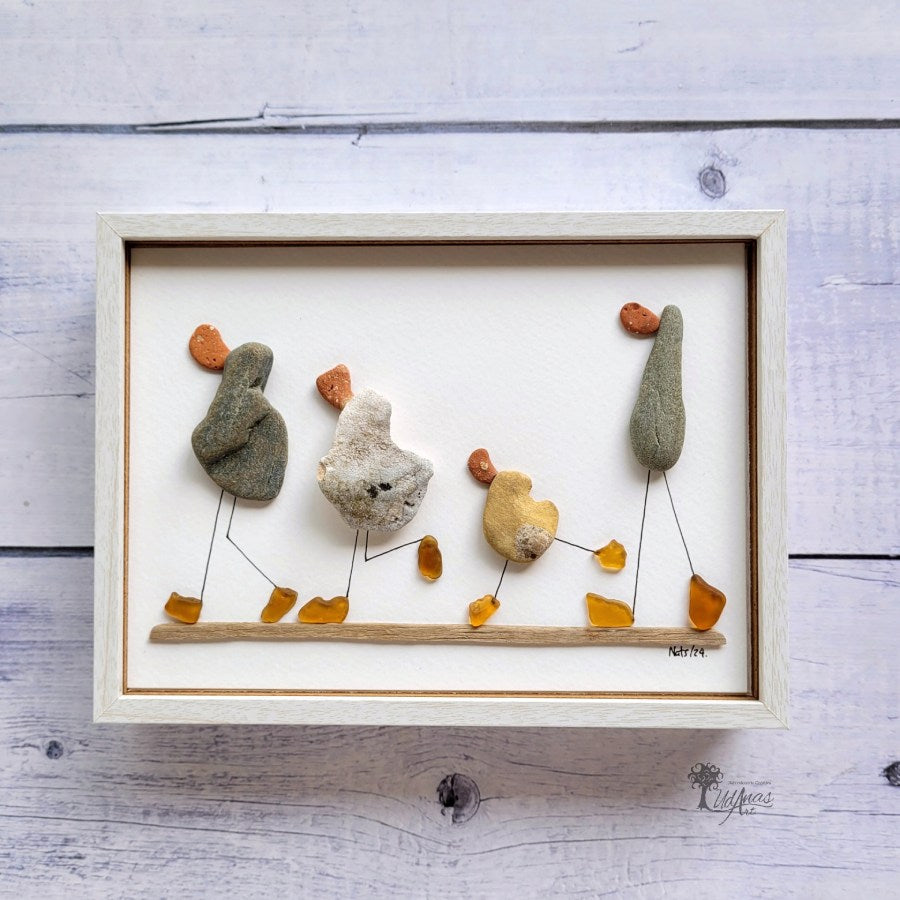 Cuadro "Cuack, cuack", patos hechos con arte reciclado, vista frontal, marco blanco colgado en pared.