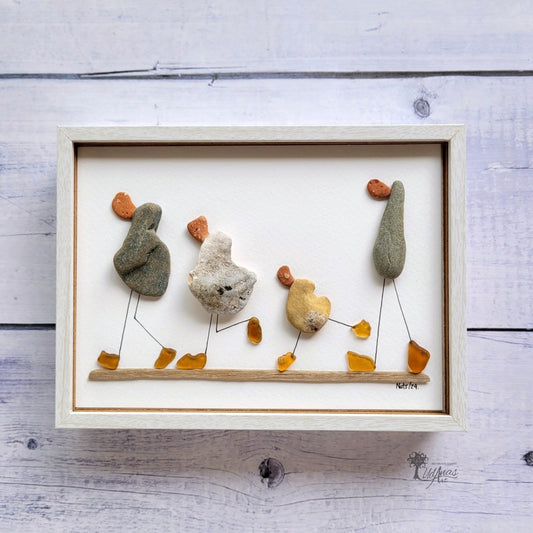 Cuadro "Cuack, cuack", patos hechos con arte reciclado, vista frontal, marco blanco colgado en pared.