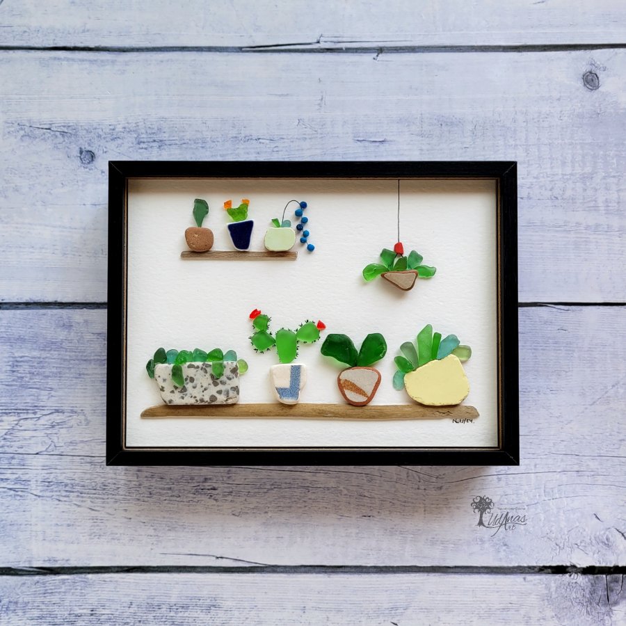 "El Jardín", cuadro de arte reciclado, vista frontal, colgado en pared con marco negro horizontal. 