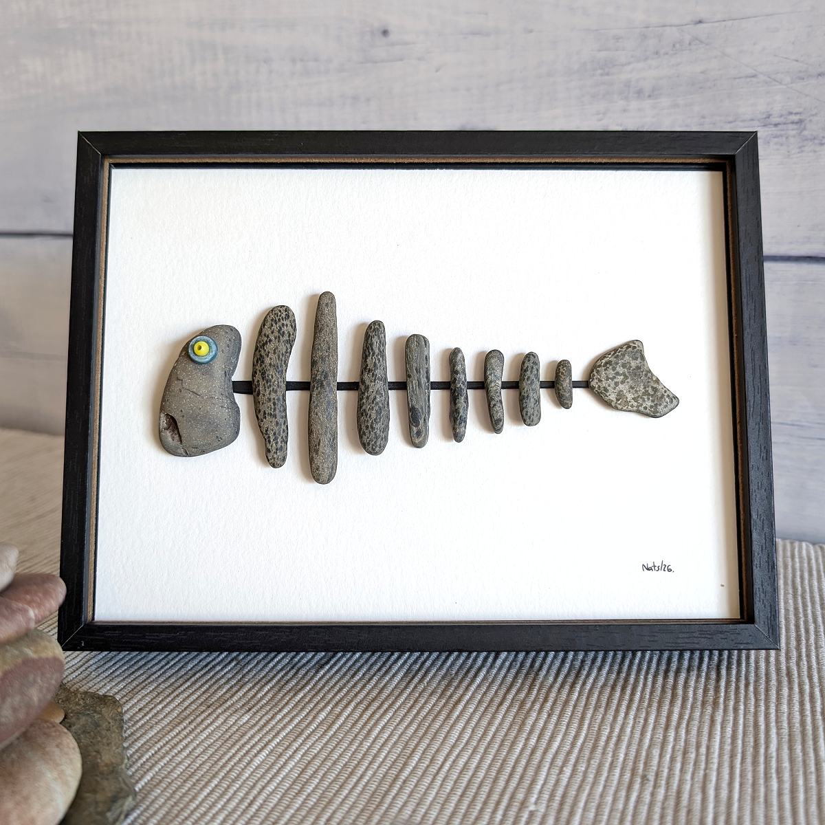 Cuadro espina de pescado, reciclaje artesanal con piedras de playa, para sobremesa, marco negro.
