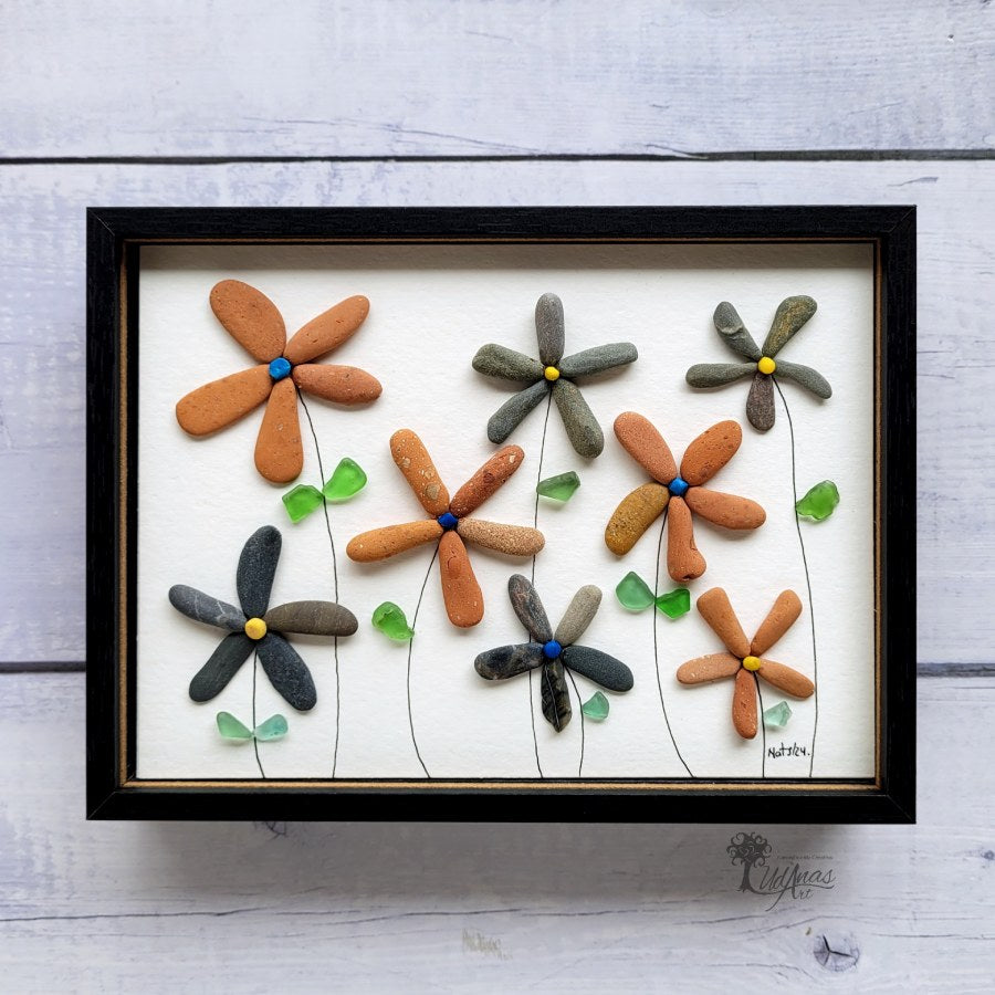 Cuadro Flores de arte reciclado, vista frontal, colgado en pared, marco negro.