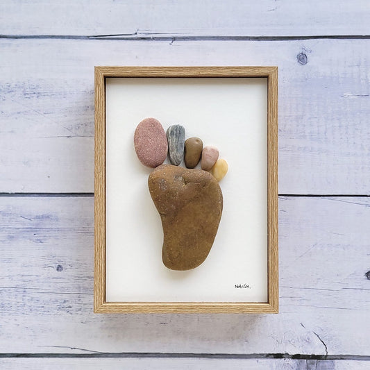 Cuadro Huella del Pie, arte sostenible, vista frontal con marco marrón, vertical, colgado en pared.