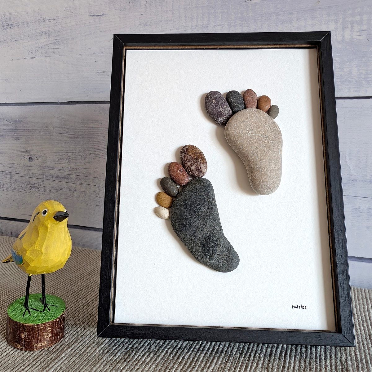 Cuadro Huellas, artesanía hecha con piedras, sobremesa, vertical, 13 x 18 cm, marco negro.