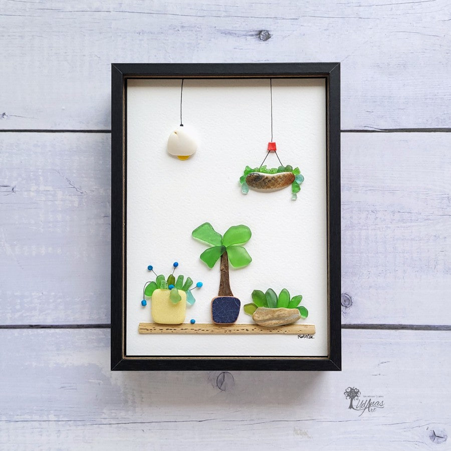 Cuadro Mi Jardín, arte reciclado, vista frontal, marco negro colgado en pared.