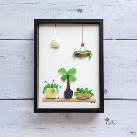 Cuadro Mi Jardín, arte reciclado, vista frontal, marco negro colgado en pared.