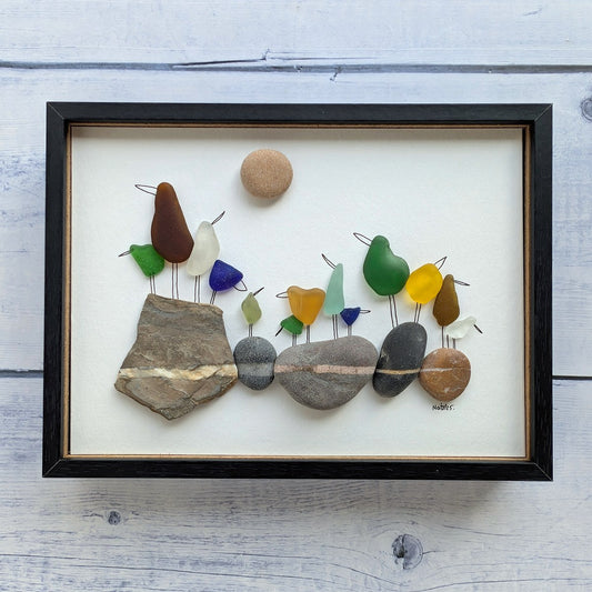 Cuadro On the Rocks, arte reciclado, vista frontal, marco negro, colgado en pared.