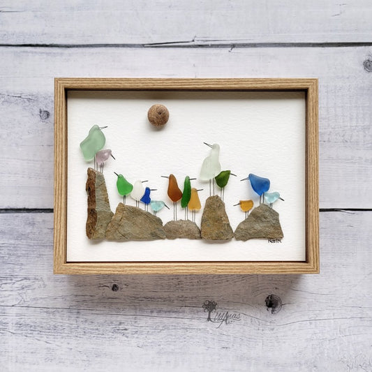 Cuadro Pájaros de Mar, arte reciclado, vista frontal, marco marrón claro, colgado en pared.