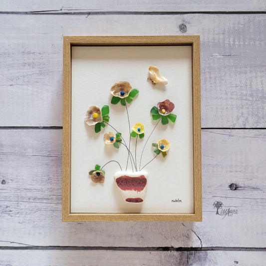 Cuadro Primavera de arte reciclado, vista frontal, colgado en pared, marco marrón claro.